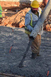 Contractor pouring concrete at a commercial worksite